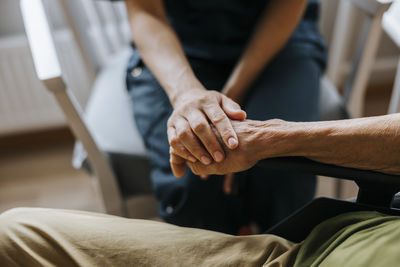 High angle view of female caregiver consoling senior patient at care home