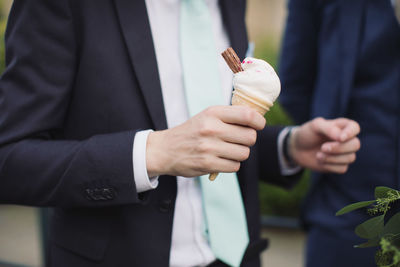 Midsection of man holding ice cream