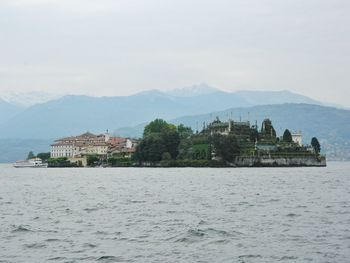 Buildings by sea against sky