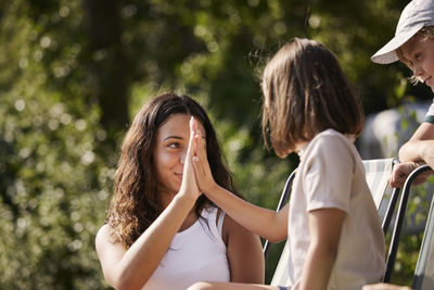 Teenage girl giving her sister high five