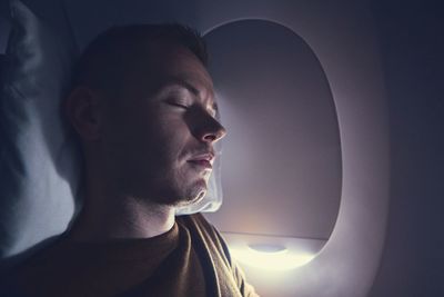 Close-up of man sleeping in airplane