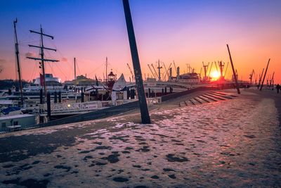 View of boats moored at harbor during sunset