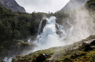 Scenic view of waterfall against sky