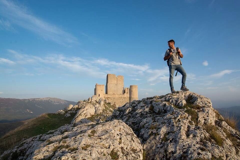 MAN STANDING ON ROCKS