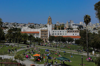 Group of people in park against buildings in city