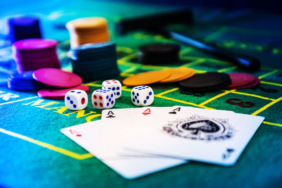 Close-up of cards by dices and gambling chips on casino table