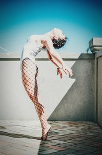 Side view full length of ballet dancer against clear sky