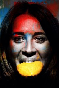 Woman with painted face eating lemon