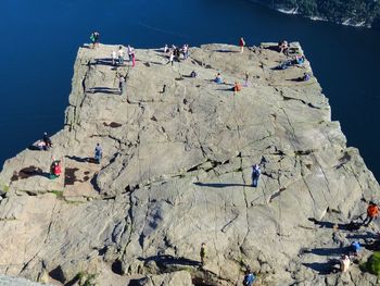 High angle view of people on rock formation by sea