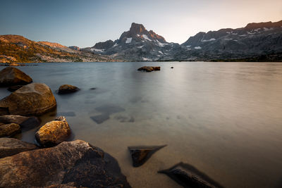 Scenic view of sea and snowcapped mountains against sky