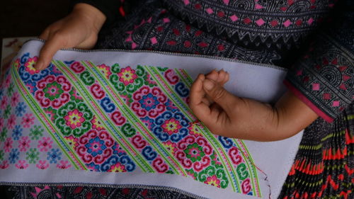 Midsection of woman sitting with textile 