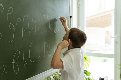 Rear view of girl drawing on wall