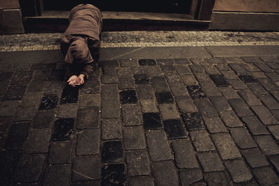 Low section of man walking on cobblestone street