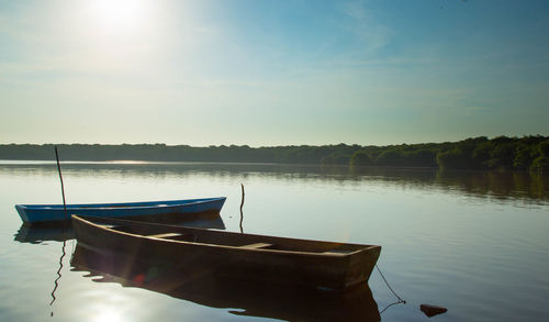 Boat moored in lake against sky