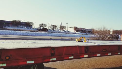 Cars on snow against clear sky during winter