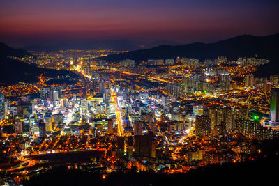 Illuminated cityscape against sky at night