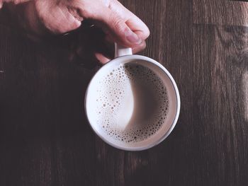 Directly above shot of hand holding coffee cup