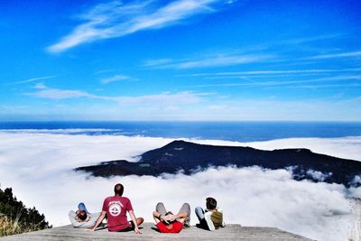 Rear view of people on mountain against sky