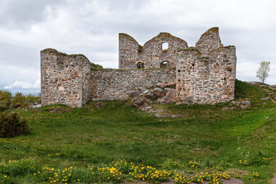 Old ruin building on field against sky