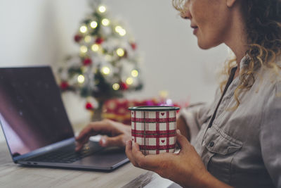 Midsection of woman using smart phone at home