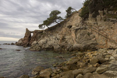 Rock formations by sea against sky