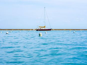 Sailboat sailing on sea against sky
