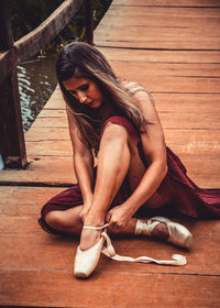 Woman sitting on wooden floor