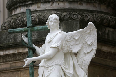 Angel statue with cross at karlskirche in karlsplatz