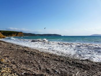 Scenic view of beach against clear blue sky