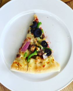 Directly above shot of pizza slice in plate on table