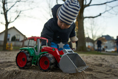 Boy playing with toy car on land