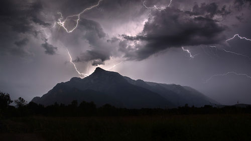 Scenic view of mountain against sky at night during thunderstorm - untersberg