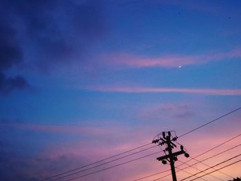 Low angle view of silhouette electricity pylon against sky during sunset