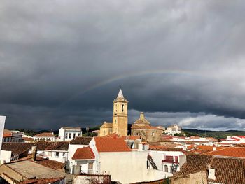Buildings in city against cloudy sky