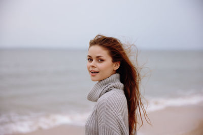 Portrait of young woman standing at beach