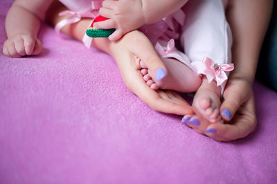 Cropped woman holding daughter legs