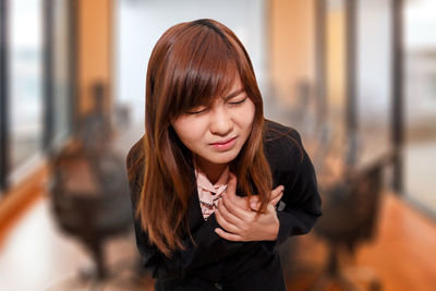 Close-up of young woman suffering from chest pain