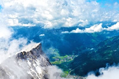 Scenic view of valley with mountains against cloudy sky