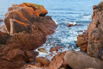 Rock formations in sea against sky