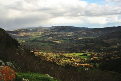 Scenic view of mountains against cloudy sky