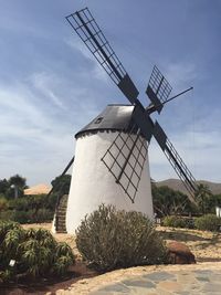 Low angle view of windmill on field against sky