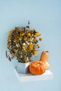 Autumn still life. pumpkins and dried flowers bouquet. modern fall concept in minimalism style.