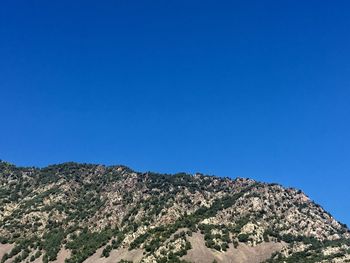 Low angle view of mountain against clear blue sky