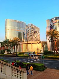 People in modern building against sky in city