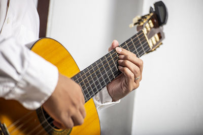 Midsection of man playing guitar