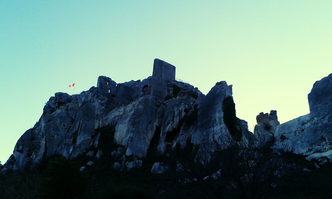 clear sky, rock formation, copy space, low angle view, rock - object, mountain, rocky mountains, tranquility, blue, scenics, tranquil scene, geology, cliff, nature, beauty in nature, physical geography, rock, eroded, non-urban scene, sky