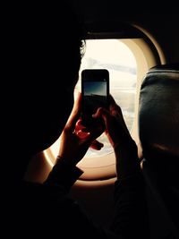 Midsection of man using mobile phone in bus