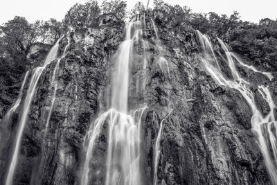 Low angle view of waterfall against sky