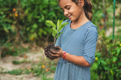 Young woman holding plant