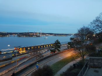 High angle view of road by illuminated city against sky